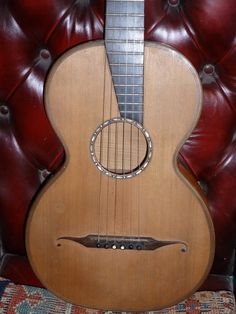 an acoustic guitar sitting on top of a couch