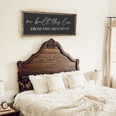 a bedroom with a large bed and a wooden sign on the wall above it that says, be beautiful this life from the ground up