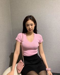 a young woman sitting on top of a toilet in a bathroom next to a wall