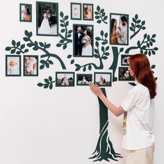 a woman standing in front of a tree with pictures on it