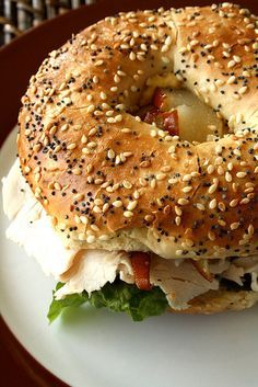 a sesame seed bagel sandwich on a white plate