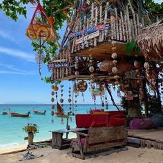 a hut on the beach with lots of decorations hanging from it