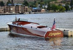 a motor boat with an american flag on it is in the water next to a dock