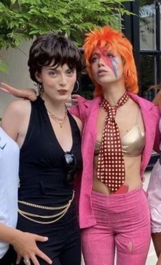 three women dressed in costumes posing for the camera