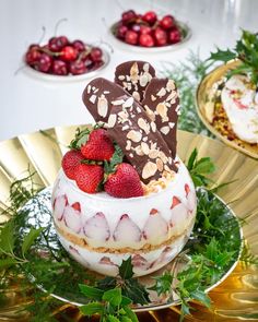 there is a cake with strawberries and chocolate on the top, surrounded by other desserts