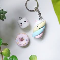 three different types of doughnuts on a white surface next to a potted plant