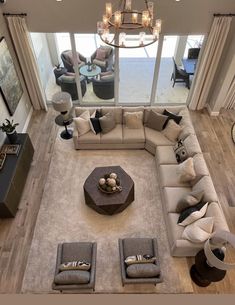 an aerial view of a living room with couches, tables and chandelier