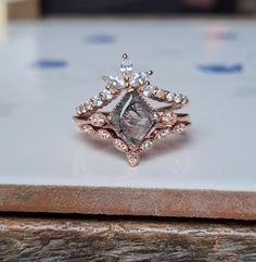 a diamond ring sitting on top of a piece of wood next to a white plate