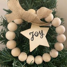 a wooden ornament with a star hanging from it's side on top of a christmas tree