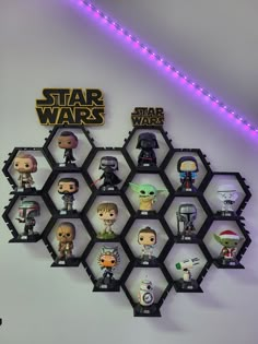 the star wars collection is on display in front of a white wall with purple lights