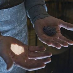 two people holding out their hands with the light shining on them and some rocks in their palms