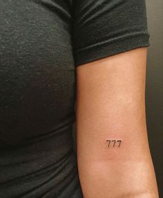 a woman's arm with a small tattoo that reads 777 on the side