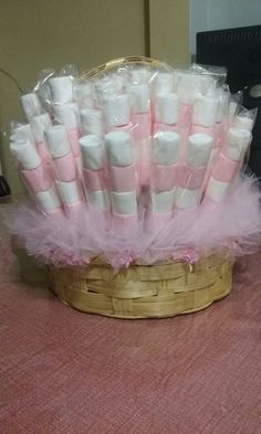 a basket filled with lots of pink and white marshmallows on top of a table