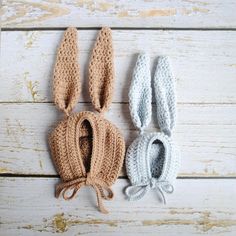 three crocheted bunnies are sitting next to each other on a wooden surface