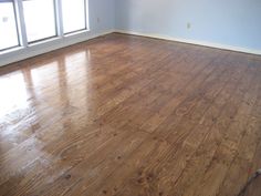 an empty room with hard wood floors and windows