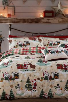 a bed covered in christmas themed sheets and pillows