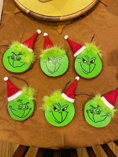 the grin face buttons are green with red and white hats on them, sitting on a table