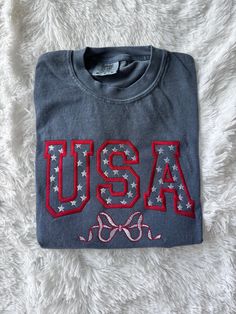 the usa t - shirt is laying on a white blanket