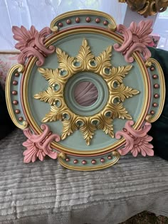 an ornately decorated tray sits on top of a cushion in front of a window