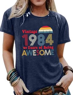 a woman wearing a blue shirt with the words, vintage forty years of being awesome