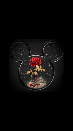 mickey mouse with a rose on it's face in the middle of a black background