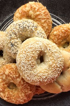 bagels with sesame seeds and poppy seed sprinkles on a black plate