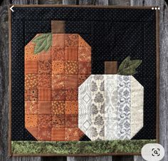 an orange quilted pumpkin sitting on top of a wooden fence next to a piece of fabric