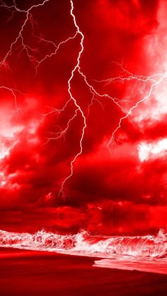 a red and black photo of a storm over the ocean with lightning striking in the sky