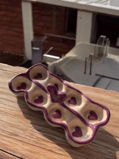 two purple and white bowls sitting on top of a wooden table next to a building