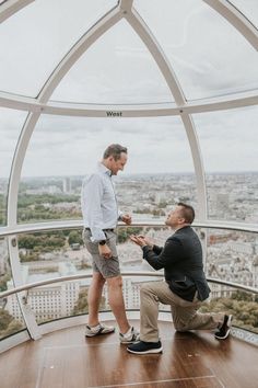 two men standing on top of a tall building looking at each other and having a conversation