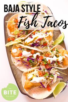 three fish tacos on a platter with lime wedges and cilantro