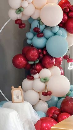 balloons are hanging from the ceiling near a table with a white dress on it and a clock