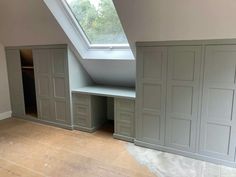 an attic bedroom with built - in closets and skylight