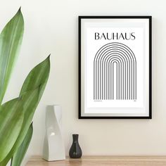 a black and white poster with the word bauhaus on it next to a potted plant