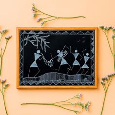 a chalkboard with some drawings on it next to flowers