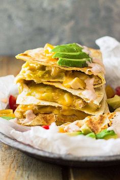 there are several quesadillas stacked on top of each other with avocado