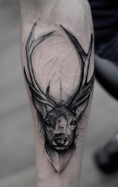 a man's leg with a black and white tattoo on it, depicting the head of a deer