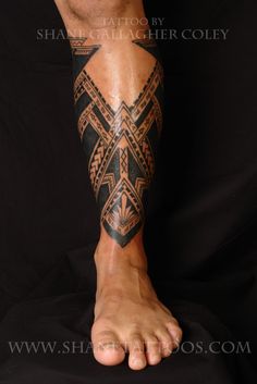 a man's leg with tattoos on it and his foot in the shape of a cross