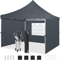 a large gray tent with the sidewalls open and two umbrellas attached to it