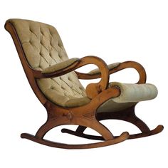 a wooden rocking chair with an upholstered seat and foot rest, on a white background