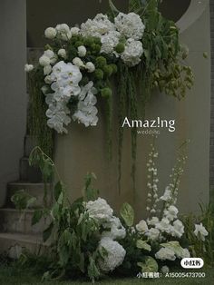 white flowers and greenery on the side of a building with words amazing wedding written below