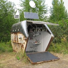 an old outhouse with solar panels on the roof