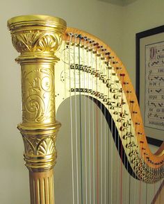 a gold colored musical instrument sitting on top of a wooden floor next to a wall