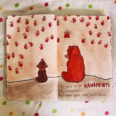 an open children's book with handprints on it and a bear sitting in the middle