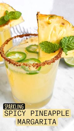 two glasses filled with pineapple and cucumber margaritas on a marble table