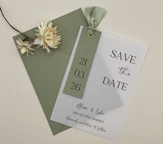 a wedding save the date card with a flower on it and a tag that says save the date