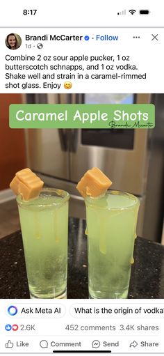 two glasses filled with green liquid sitting on top of a counter