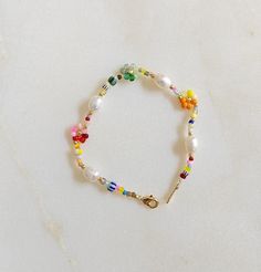 ✋100% HANDMADE Handmade daisy bracelet in vibrant rainbow beads. The refreshing combination of colors will brighten up your day, while the durable materials ensure long-lasting wear. Perfect for gifting or treating yourself! 📏SIZE: 17cm long / 6.69 inch * If you need other lengths, please contact me or leave a message with your order.🌷  📿 MATERIALS: 6-8mm real freshwater pearl 2-5mm glass beads 14K Gold plated clasp 🎁 PACKAGING: Each piece comes with a dust/moisture proof bag and a cotton ba Seed Bead Daisy, Bead Daisy, Surf Jewelry, Bracelet Cute, Bracelet Flower, Daisy Bracelet, Seed Bead Bracelet, Combination Of Colors, Rainbow Beads