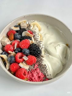 a bowl filled with yogurt, berries and nuts