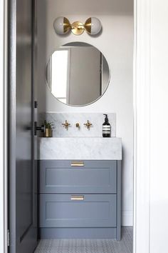 a bathroom with a sink, mirror and light fixture in it's centerpiece